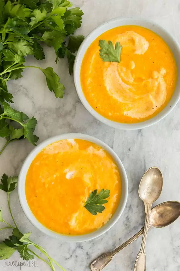 Yummy carrot ginger soup recipe in two white bowls, made in the instant pot